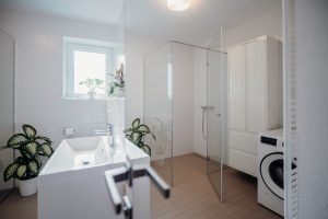 Minimalistický sklený sprchový kút s chrómovými detailami